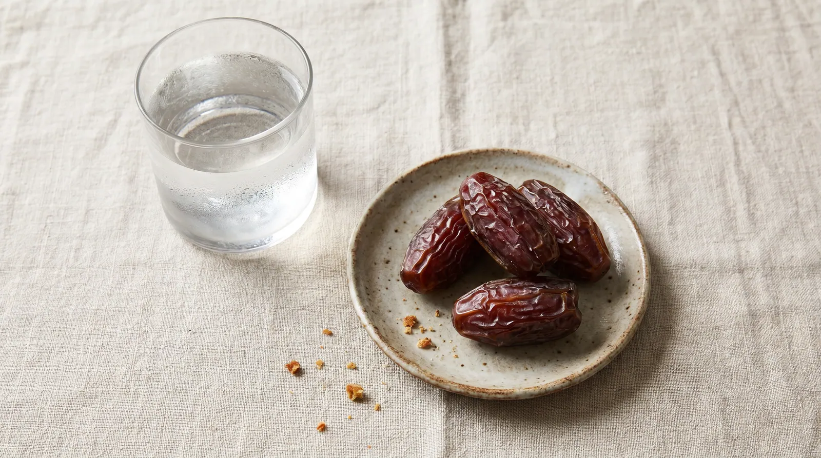 Two dates and a glass of water on a Ramadan Iftar table