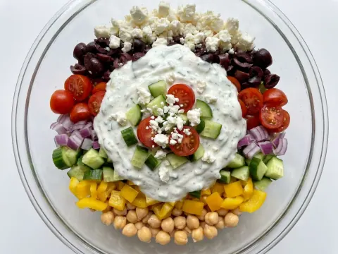 Layered Mediterranean Salad with Yogurt and Cucumber Dressing